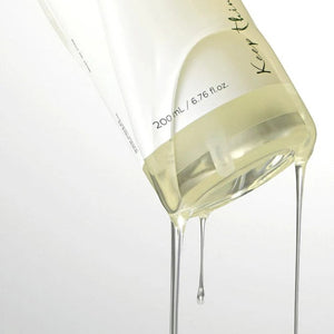 Skin TOGO Anua Heartleaf Pore Control Cleansing Oil dripping from a clear bottle against a white background