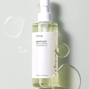 Skin TOGO Anua Heartleaf Pore Control Cleansing Oil in a clear pump bottle with droplets of oil on a soft green background