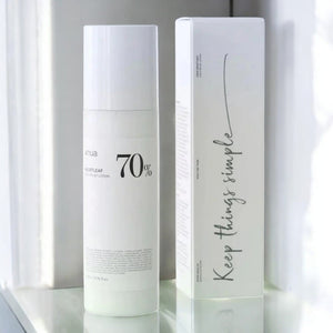 Skin TOGO Anua Heartleaf 70% Daily Lotion bottle and its minimalist white packaging box on a reflective surface.