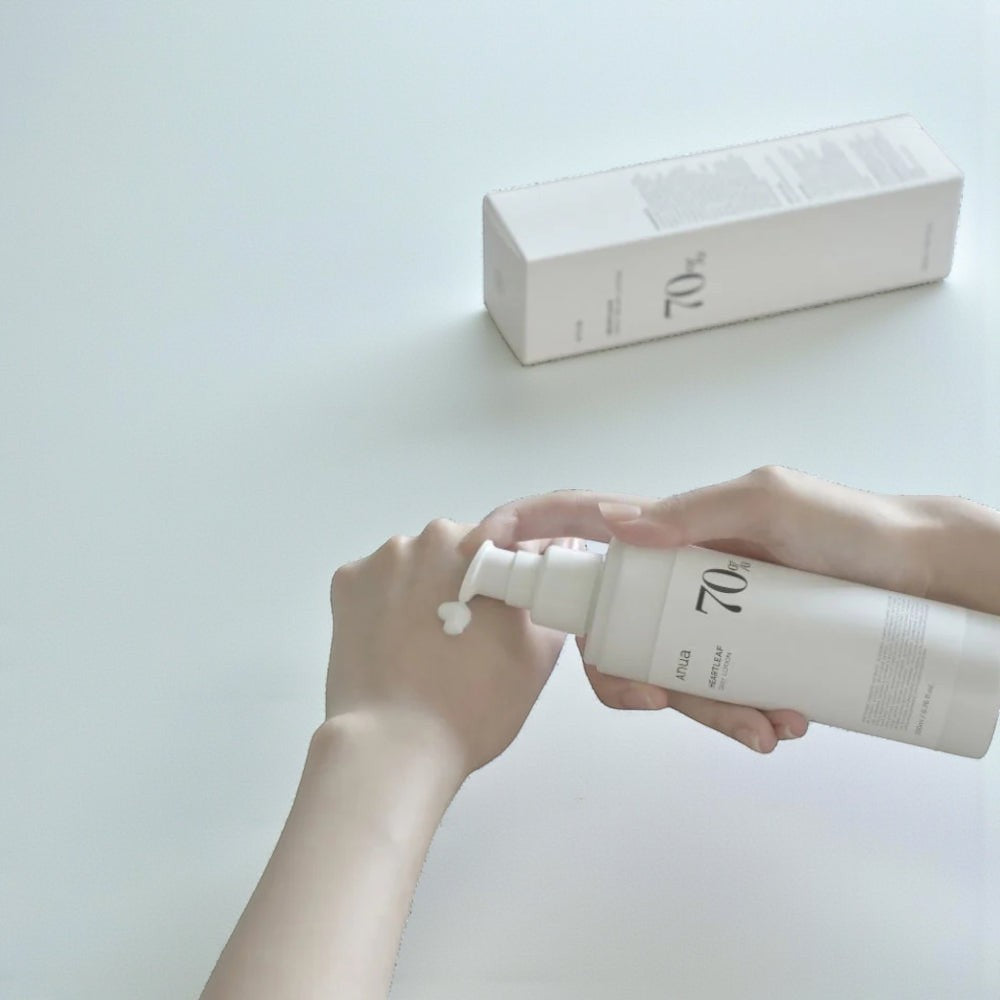 Skin TOGO Anua Heartleaf 70% Daily Lotion being applied to a hand, showing the lightweight white cream texture.