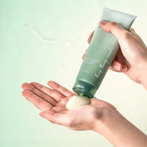 Skin TOGO Anua Heartleaf LHA Moisture Peeling Gel being squeezed from a green tube onto a palm for skincare