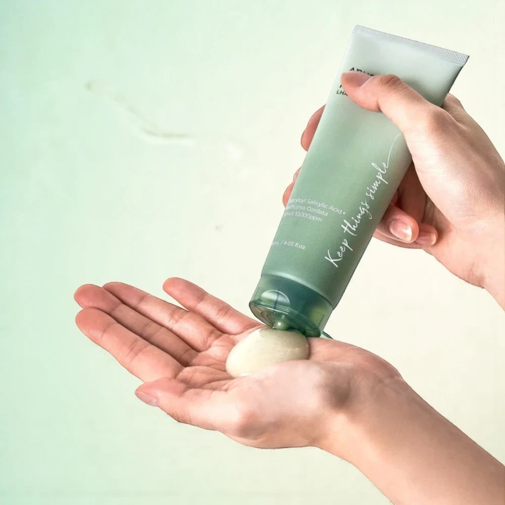 Skin TOGO Anua Heartleaf LHA Moisture Peeling Gel being squeezed from a green tube onto a palm for skincare