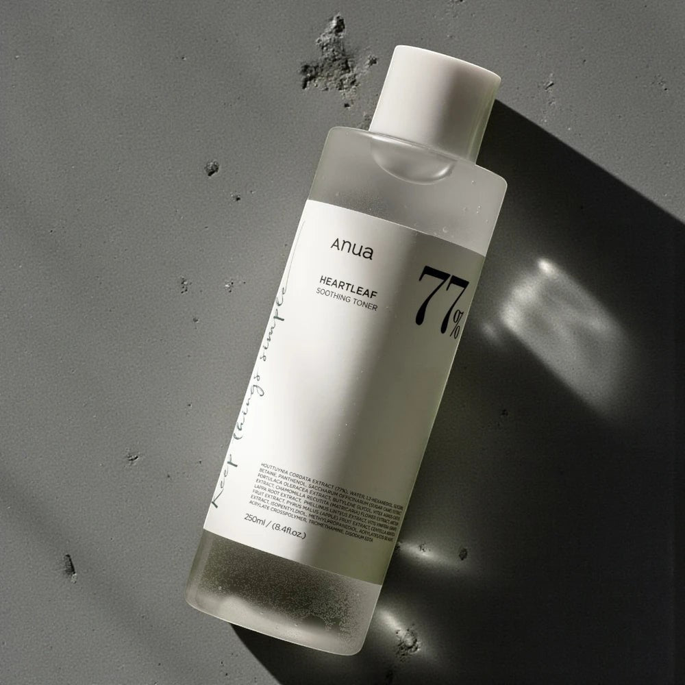 Skin TOGO Anua Heartleaf 77 Soothing Toner in a 250ml clear bottle on a textured grey surface.