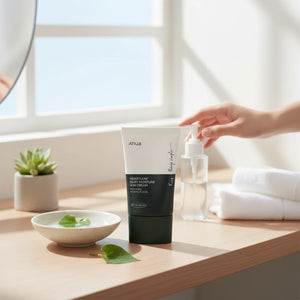 Skin TOGO Anua Heartleaf Silky Moisture Sun Cream SPF50+ tube on a wooden table with a small bowl and green leaf.