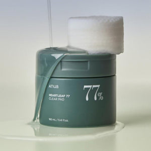 Skin TOGO ANUA Heartleaf 77% Clear Pad toner pads in a green jar with a single pad on top and liquid dripping down
