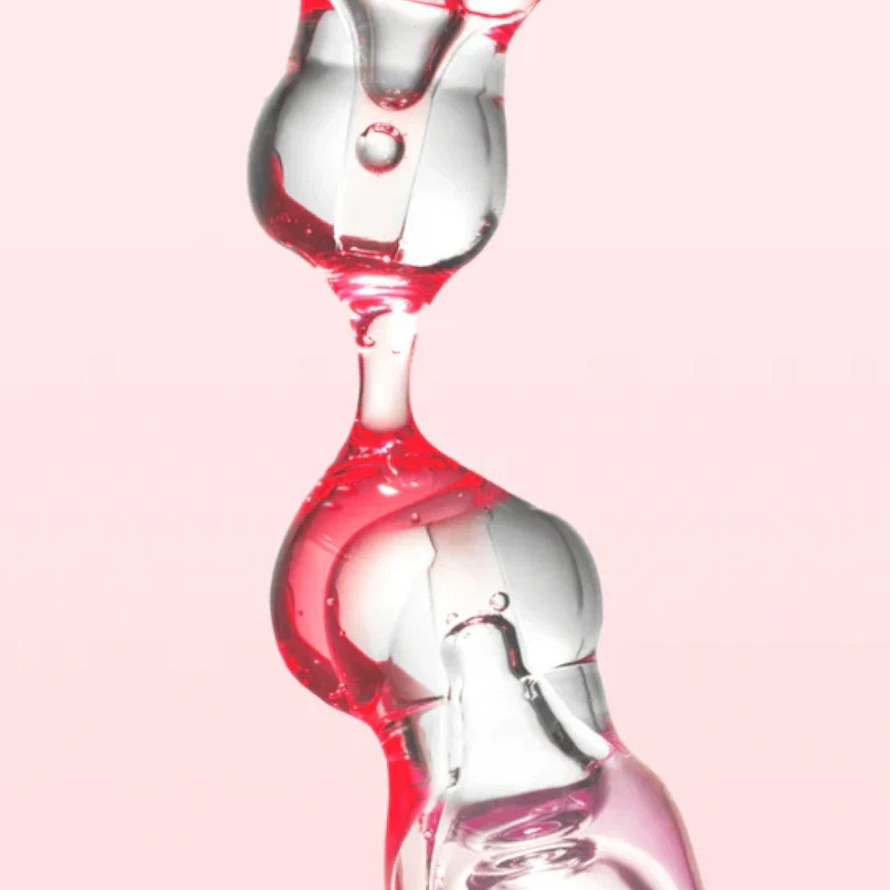 Skin TOGO Anua Niacinamide 10% and TXA 4% serum texture showing clear and pink liquid droplets against a soft background