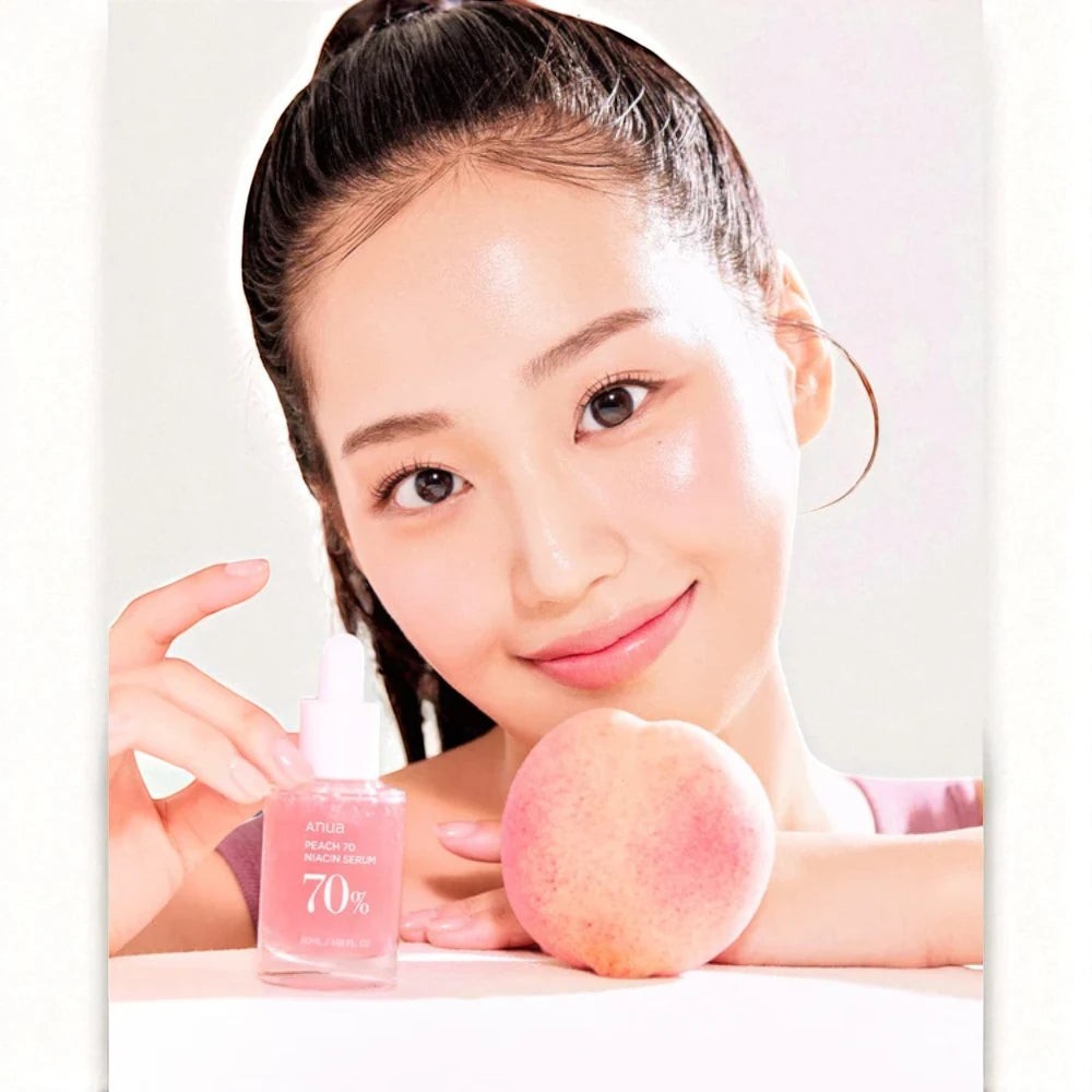 Skin TOGO model holding an Anua Peach 70% Niacin Serum bottle next to a fresh peach for a glowing skincare routine.