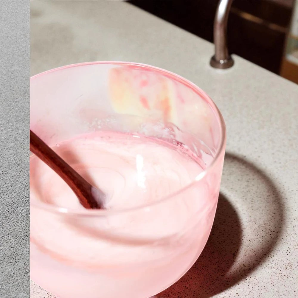 Skin TOGO Anua Peach 70% Niacin Serum in a pink glass bowl with a wooden spoon, highlighting its light, creamy texture.