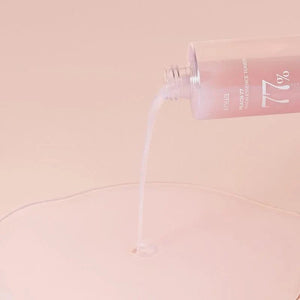 Skin TOGO Anua Peach 77 Niacin Conditioning Milk Toner pouring its creamy, milky texture onto a soft peach surface.