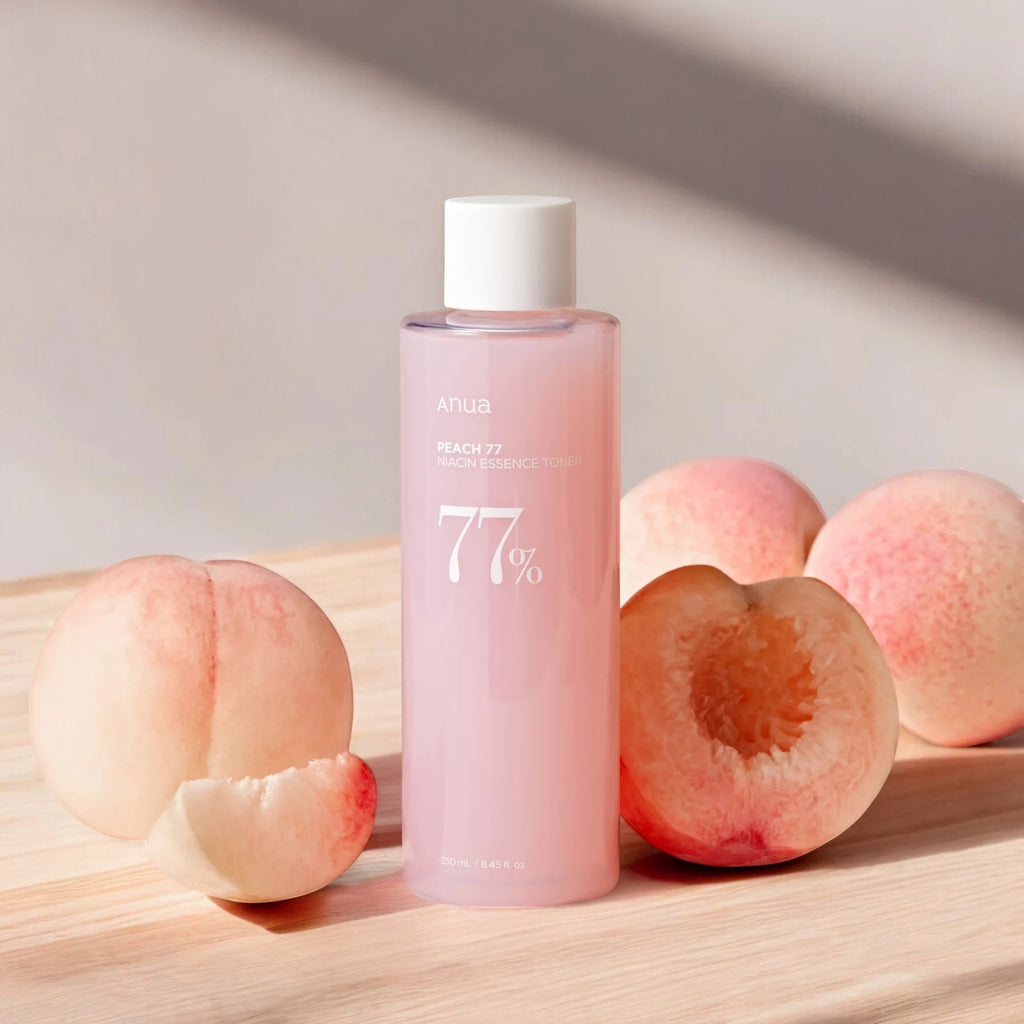Skin TOGO Anua Peach 77 Niacin Conditioning Milk Toner bottle surrounded by fresh peaches on a wooden surface.