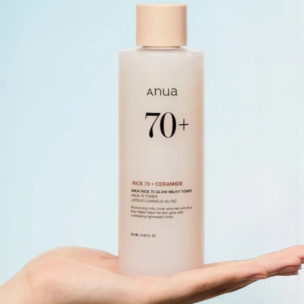Skin TOGO Anua Rice 70 Glow Milky Toner in a 250ml bottle held in a hand, featuring a light beige cap.
