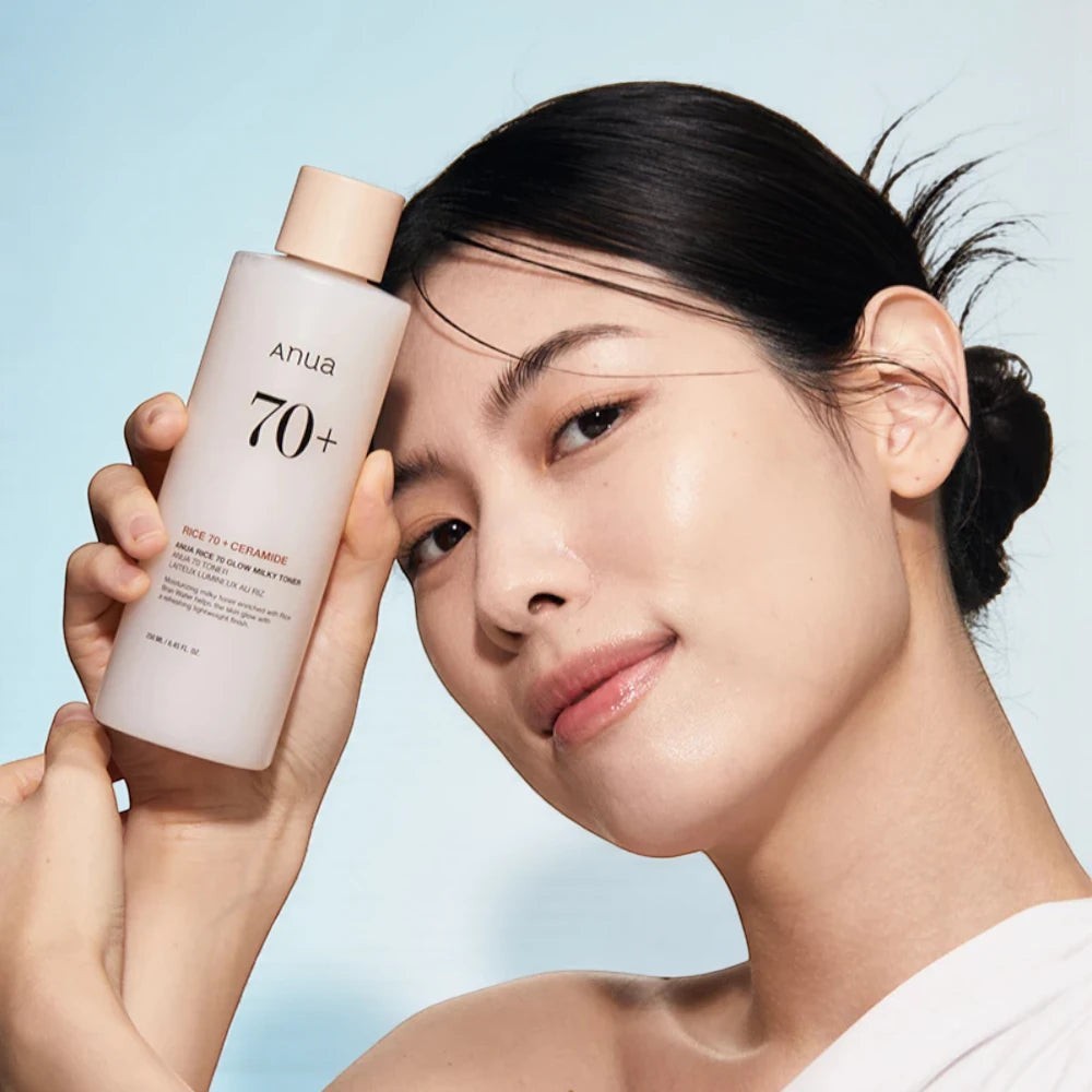 Skin TOGO model holding Anua Rice 70 Glow Milky Toner, a brightening skincare product for radiant skin.