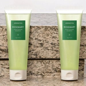 Skin TOGO Aromatica Rosemary Scalp Scaling Shampoo in two translucent green tubes on a stone surface.