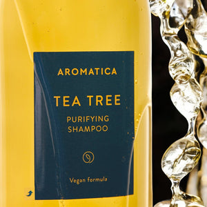 Skin TOGO Aromatica Tea Tree Purifying Shampoo bottle with golden liquid and refreshing water splash effect.