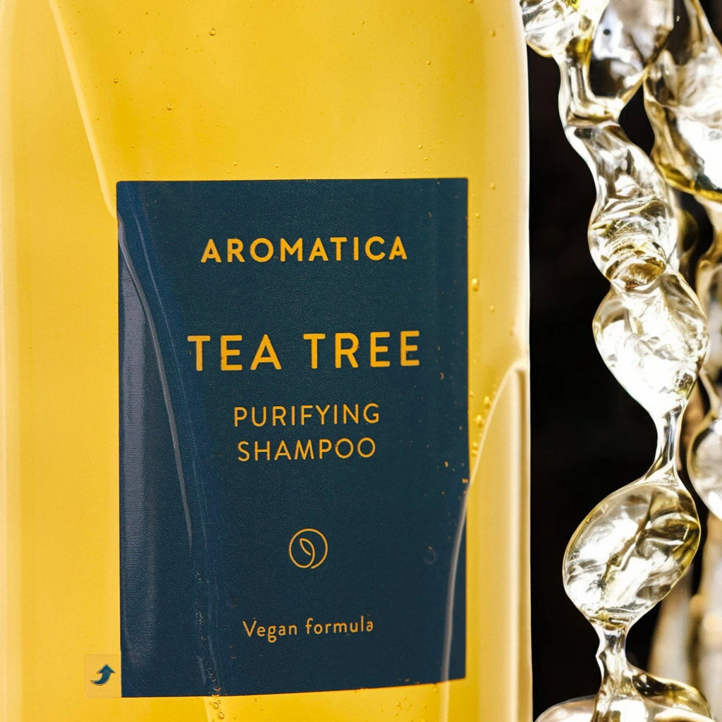 Skin TOGO Aromatica Tea Tree Purifying Shampoo bottle with golden liquid and refreshing water splash effect.