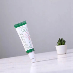 Skin TOGO Axis-Y Dark Spot Correcting Glow Serum in a white tube with green cap standing on a white surface.