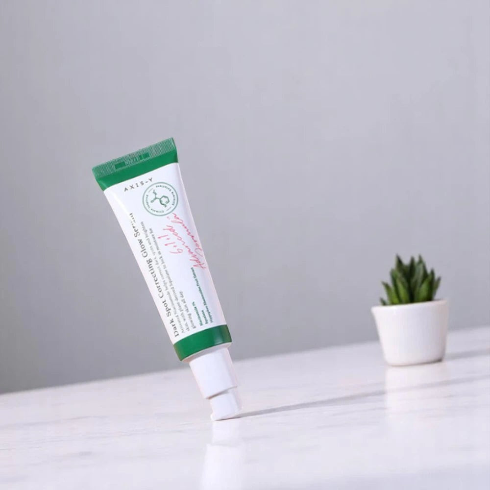 Skin TOGO Axis-Y Dark Spot Correcting Glow Serum in a white tube with green cap standing on a white surface.