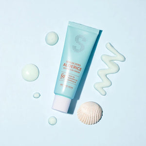 Skin TOGO Be The Skin Sebum Zero Aloerice SPF 50+ suncream tube with cream swatches and a seashell on blue background