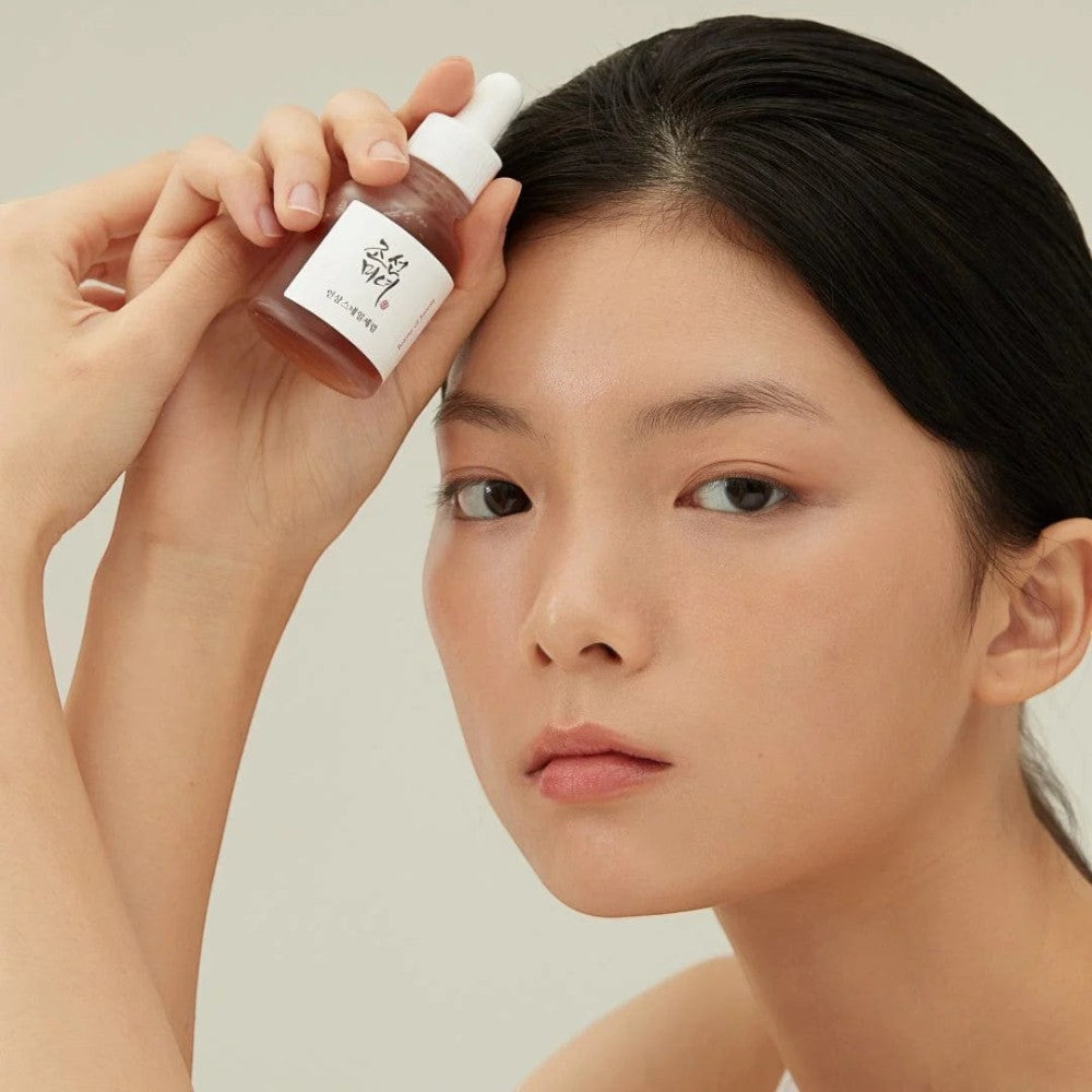 Skin TOGO model holding Beauty of Joseon Revive Ginseng and Snail Mucin serum bottle for skincare routine