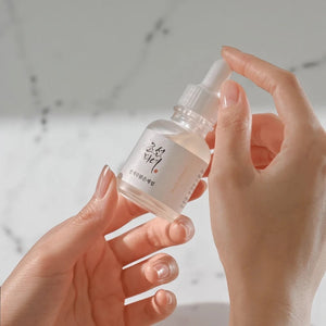 Skin TOGO Beauty of Joseon Glow Deep Serum bottle held in hands, featuring rice and arbutin for skin brightening.