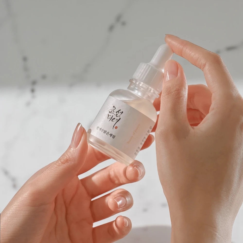 Skin TOGO Beauty of Joseon Glow Deep Serum bottle held in hands, featuring rice and arbutin for skin brightening.