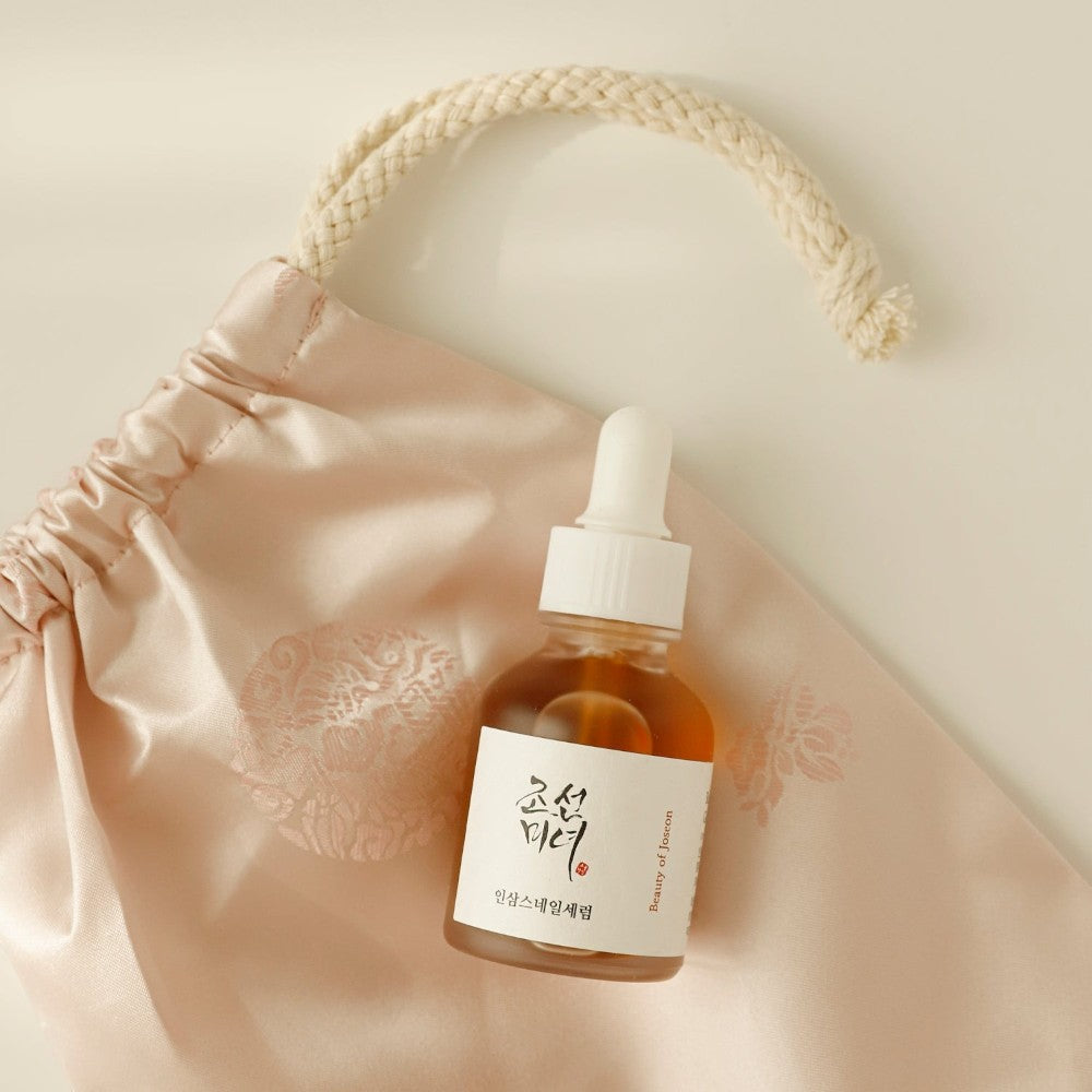 Skin TOGO Beauty of Joseon Revive Serum with ginseng and snail mucin in a 30ml dropper bottle on a silk pouch.