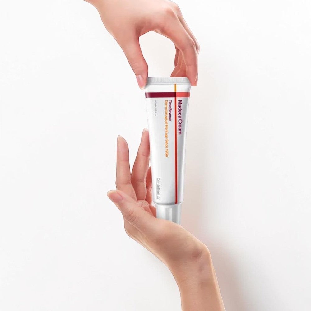 Skin TOGO Centellian 24 Madeca Cream Time Reverse anti-aging moisturizer in a white tube held by hands