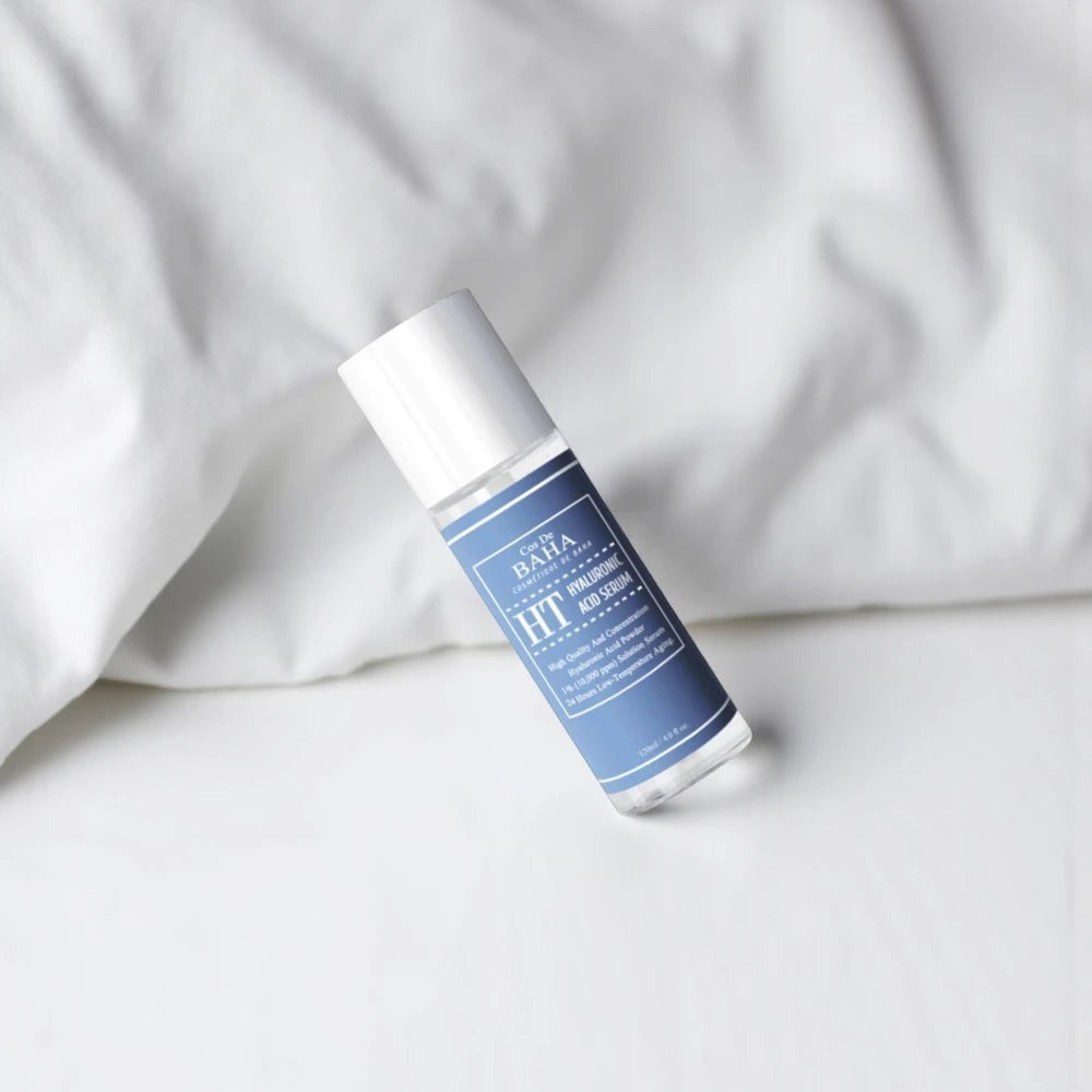 Skin TOGO Cos De BAHA H Hyaluronic Acid Serum in a clear 120ml bottle with a blue label on a white fabric background.