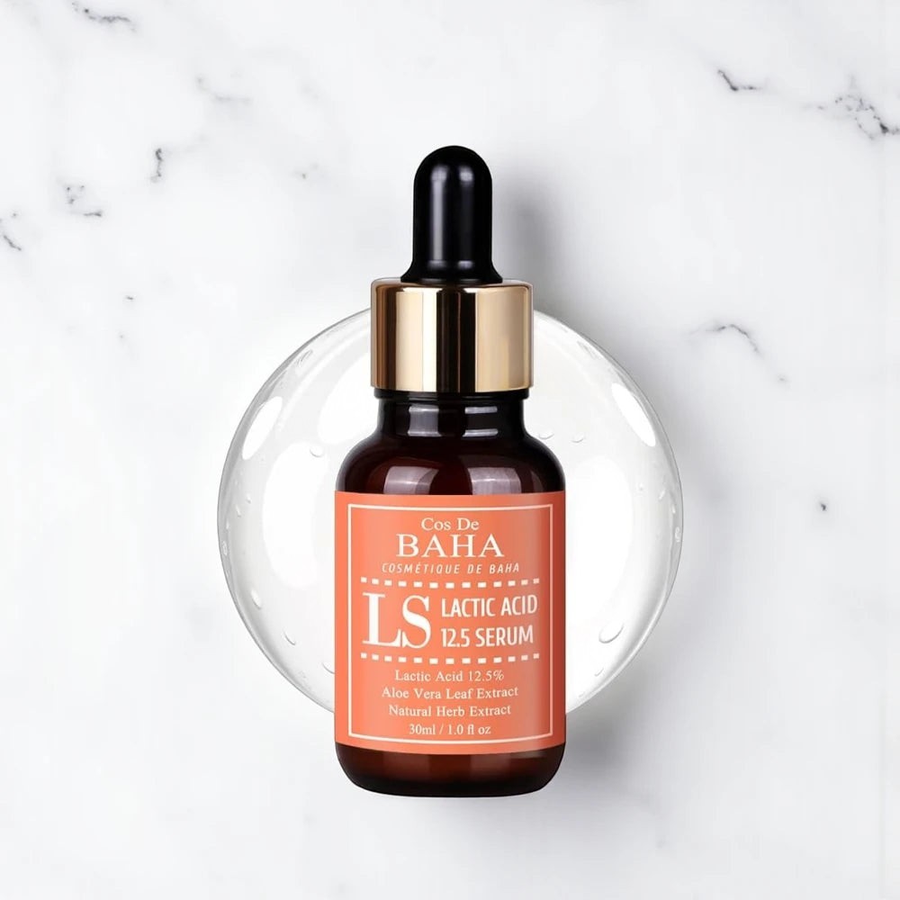 Skin TOGO Cos De BAHA LS Lactic Acid 12.5% exfoliating serum in a brown glass dropper bottle on a marble surface.