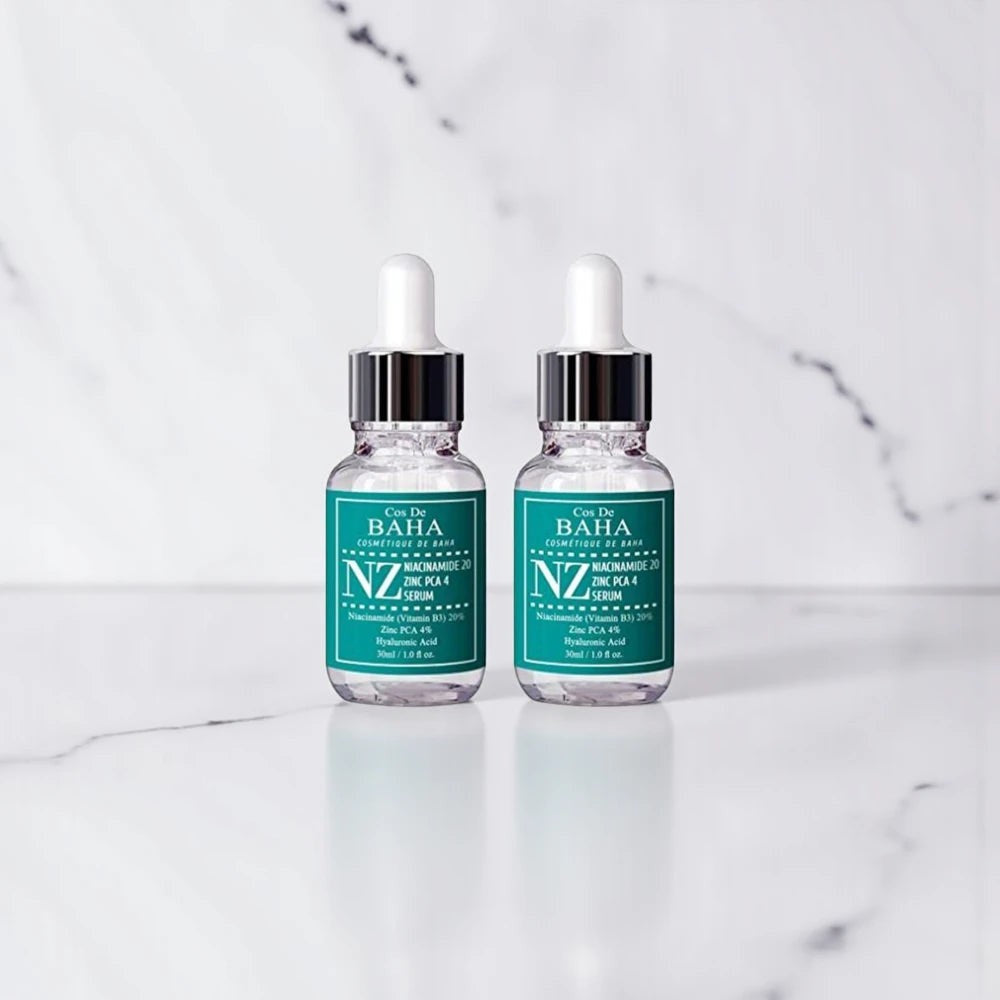 Skin TOGO Cos De BAHA NZ Niacinamide 20% and Zinc PCA 4% serum bottles on a marble surface.