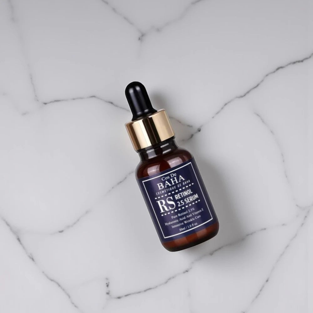 Skin TOGO Cos De BAHA RS Retinol 2.5% serum in a brown glass dropper bottle on a white marble surface.
