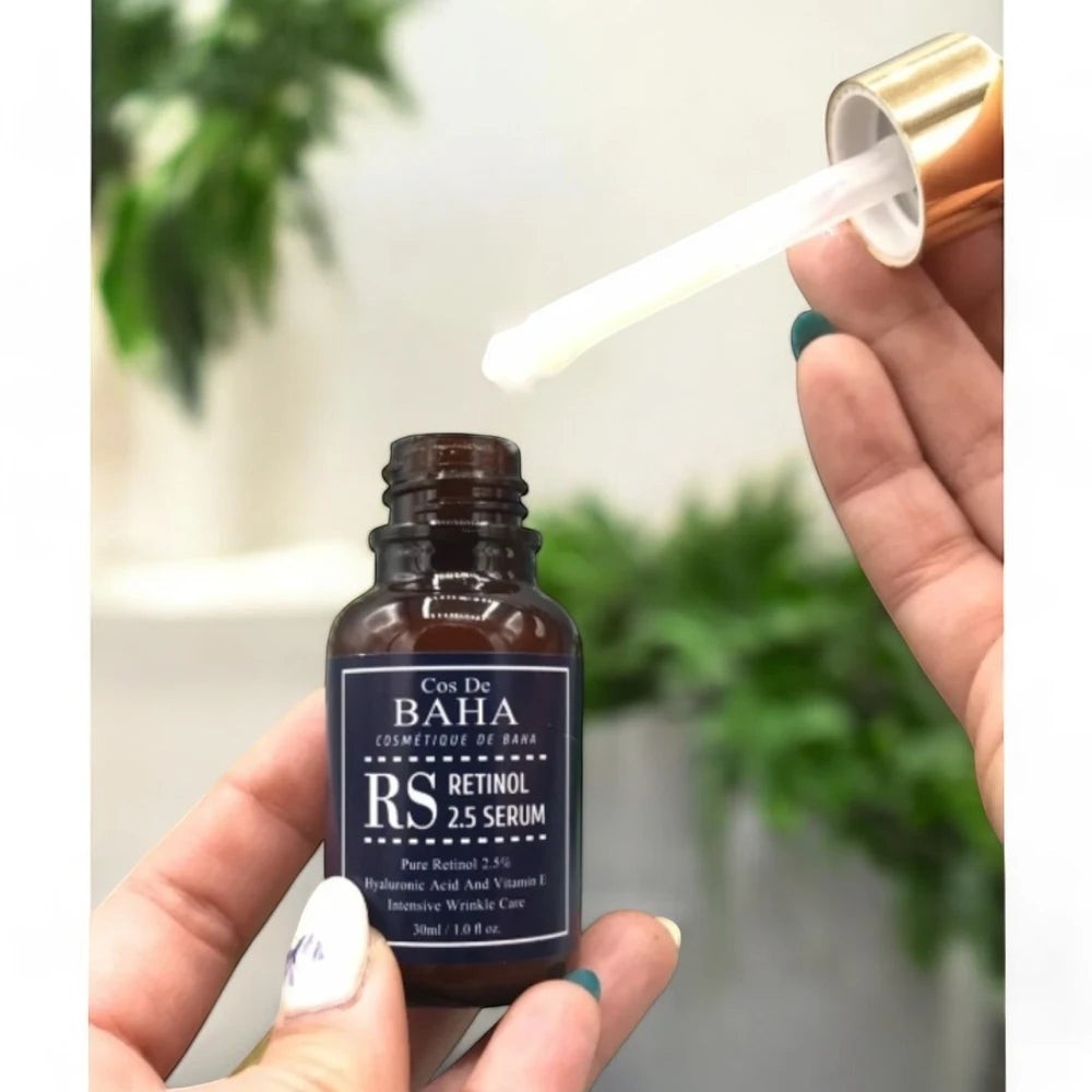 Skin TOGO Cos De BAHA RS Retinol 2.5% serum in a brown glass bottle with a dropper being held by a hand.