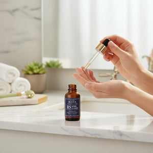 Skin TOGO Cos De BAHA RS Retinol 2.5% serum in a brown glass dropper bottle held over a marble bathroom counter.