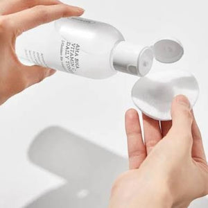 Skin TOGO COSRX AHA BHA Vitamin C Daily Toner being poured onto a cotton pad for gentle facial exfoliation.