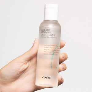 Skin TOGO COSRX AHA BHA Vitamin C Daily Toner in a clear 150ml bottle held in a hand for skincare routine