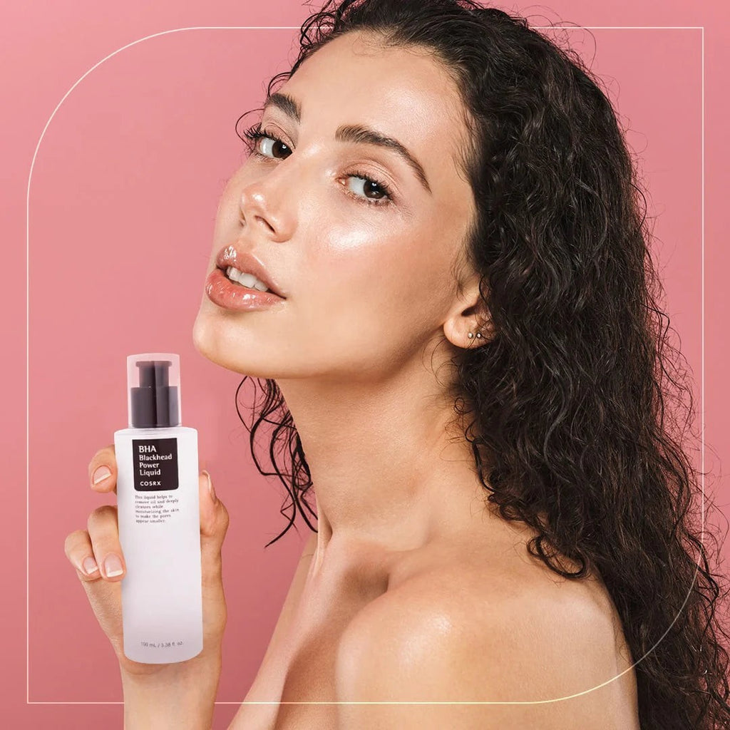 Skin TOGO model holding a bottle of Cosrx BHA Blackhead Power Liquid chemical exfoliant for clear skin