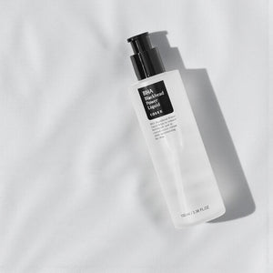 Skin TOGO Cosrx BHA Blackhead Power Liquid exfoliating serum bottle on a soft white fabric background