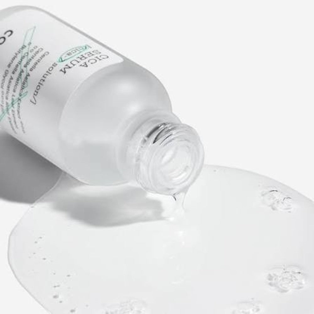 Skin TOGO COSRX Pure Fit Cica Serum bottle pouring a clear, lightweight soothing facial serum onto a white surface.