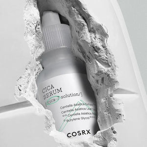 Skin TOGO COSRX Pure Fit Cica Serum in a 30ml bottle, displayed through a textured white stone opening.