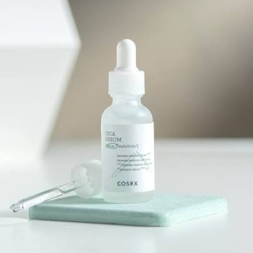 Skin TOGO COSRX Pure Fit Cica Serum in a clear glass dropper bottle on a light green stone base for sensitive skin.