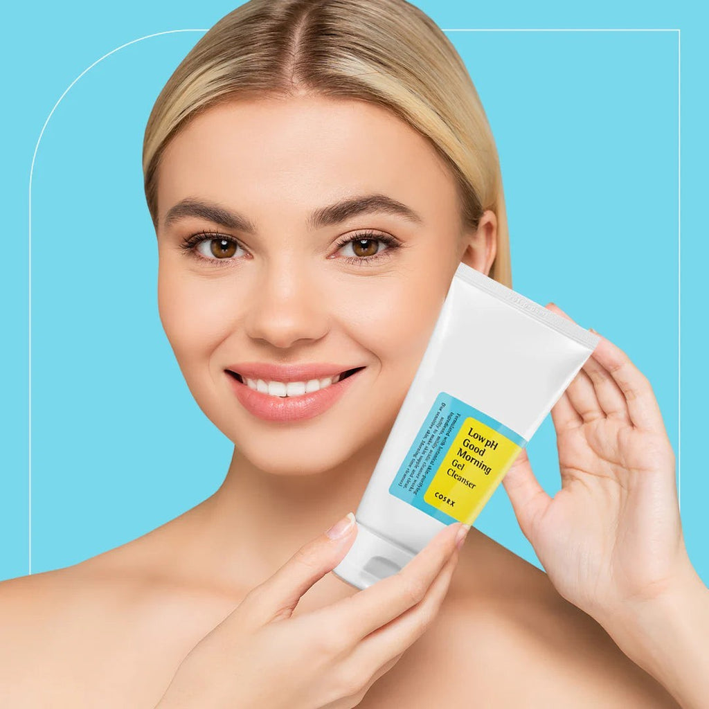 Skin TOGO model holding a white tube of Cosrx Low pH Good Morning Gel Cleanser against a light blue background.