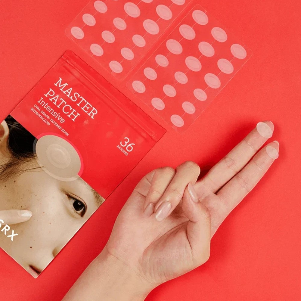 Skin TOGO Cosrx Master Patch Intensive hydrocolloid acne patches on a red background with a hand holding a patch.