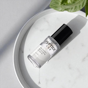 Skin TOGO COSRX Peptide-132 hair bonding oil serum in a clear bottle on a white marble tray with a green leaf.