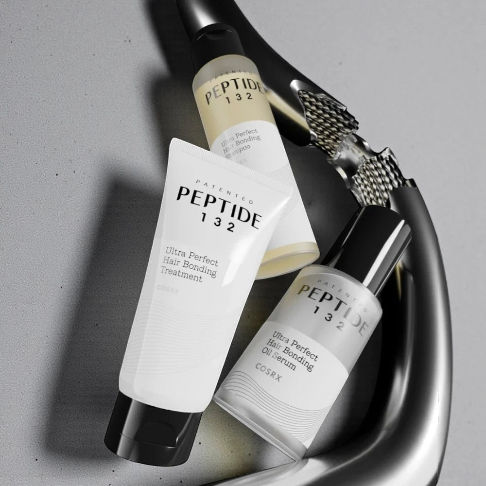 Skin TOGO COSRX Peptide-132 hair bonding shampoo, treatment, and oil serum set on a grey surface with a metal faucet.