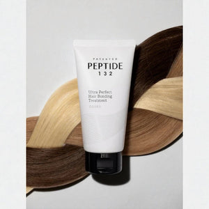 Skin TOGO COSRX Peptide-132 Ultra Perfect Hair Bonding Treatment tube resting on braided blonde and brown hair strands