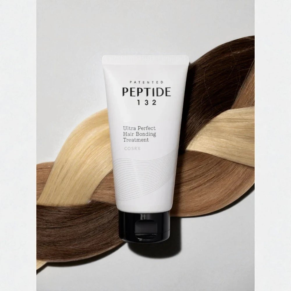 Skin TOGO COSRX Peptide-132 Ultra Perfect Hair Bonding Treatment tube resting on braided blonde and brown hair strands