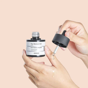 Skin TOGO COSRX The Retinol 0.5 Oil serum bottle with dropper being applied to hand for anti-aging skincare
