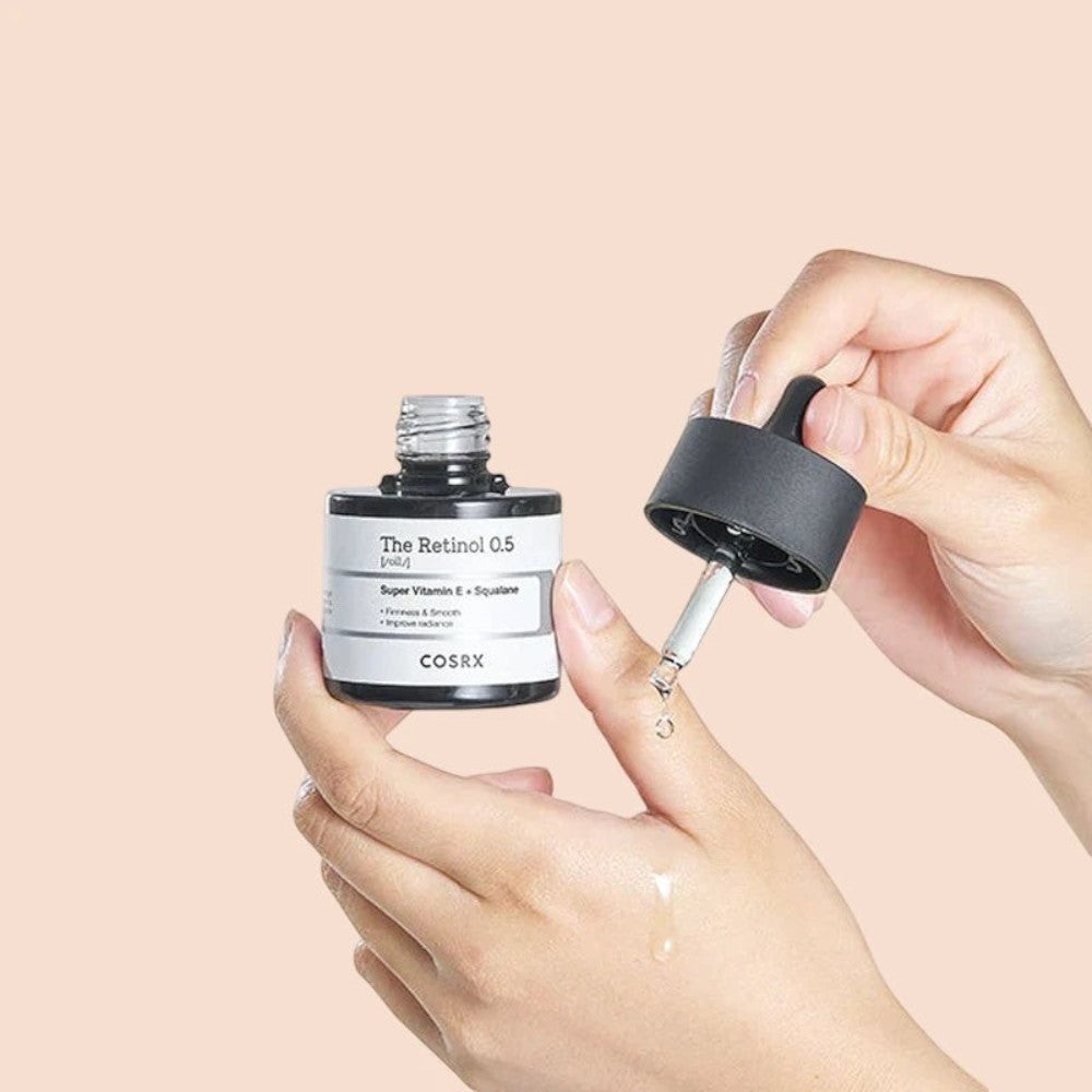 Skin TOGO COSRX The Retinol 0.5 Oil serum bottle with dropper being applied to hand for anti-aging skincare