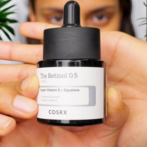 Skin TOGO COSRX The Retinol 0.5 Oil serum bottle held in hand, featuring squalane and vitamin E for anti-aging.