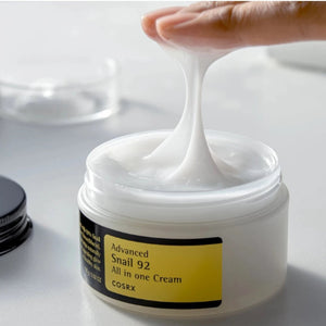 Skin TOGO Cosrx Advanced Snail 92 All In One Cream with a finger pulling a stringy, lightweight gel-cream texture.